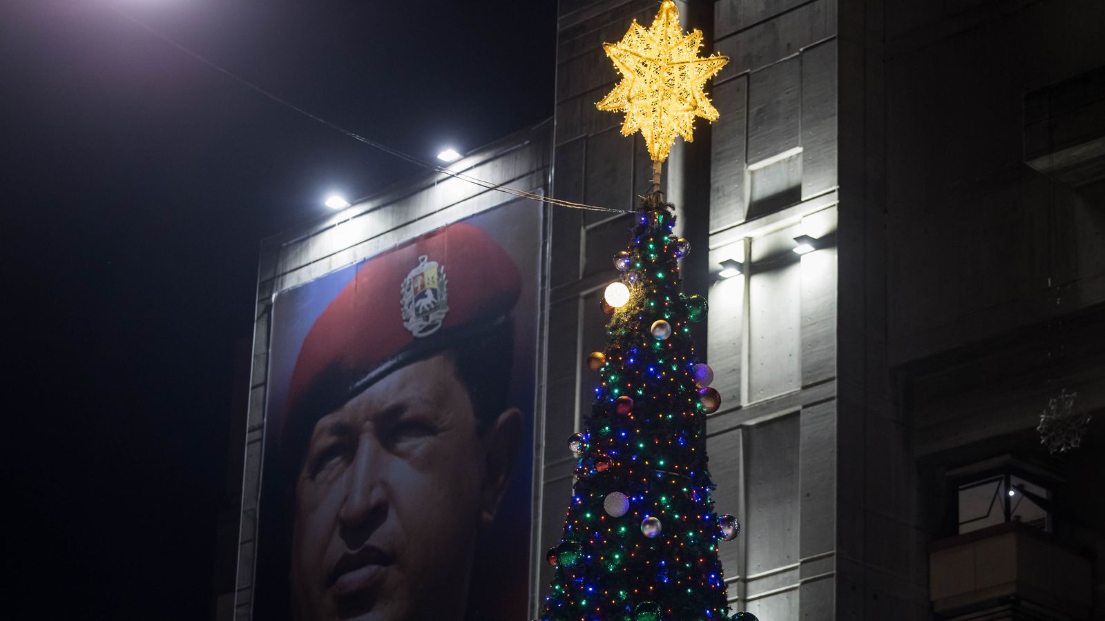 Un arbre de Nadal al centre de Caracas al costat d'un cartell de l'expresident Hugo Chávez