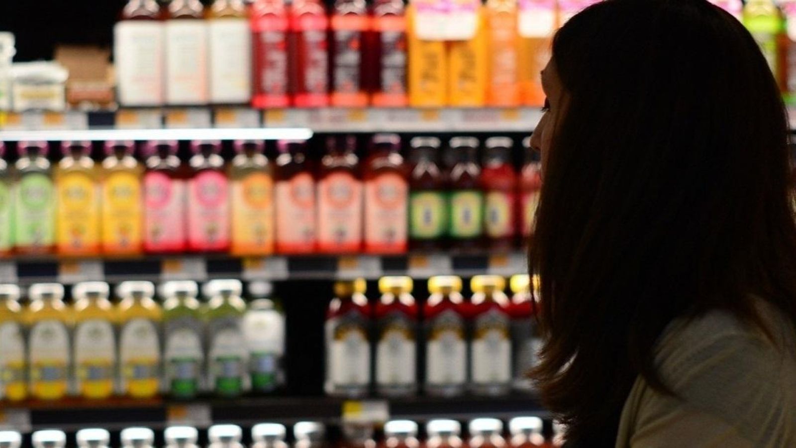 Una dona observa la prestatgeria d'un supermercat