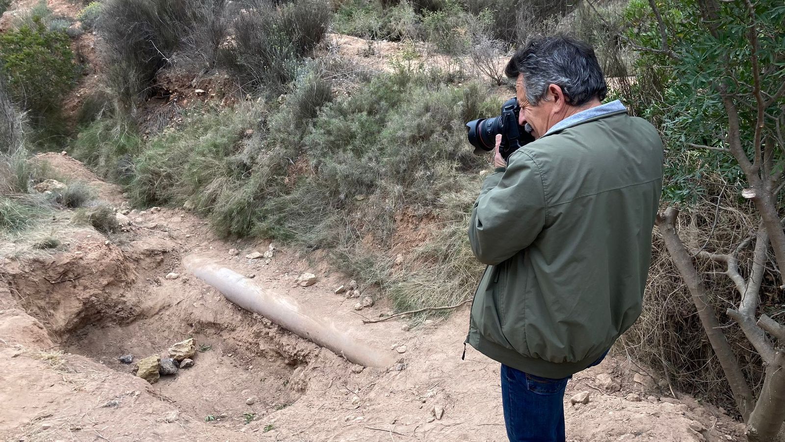 Un reporter gràfic fotografia el forat on hi havia els cadàvers