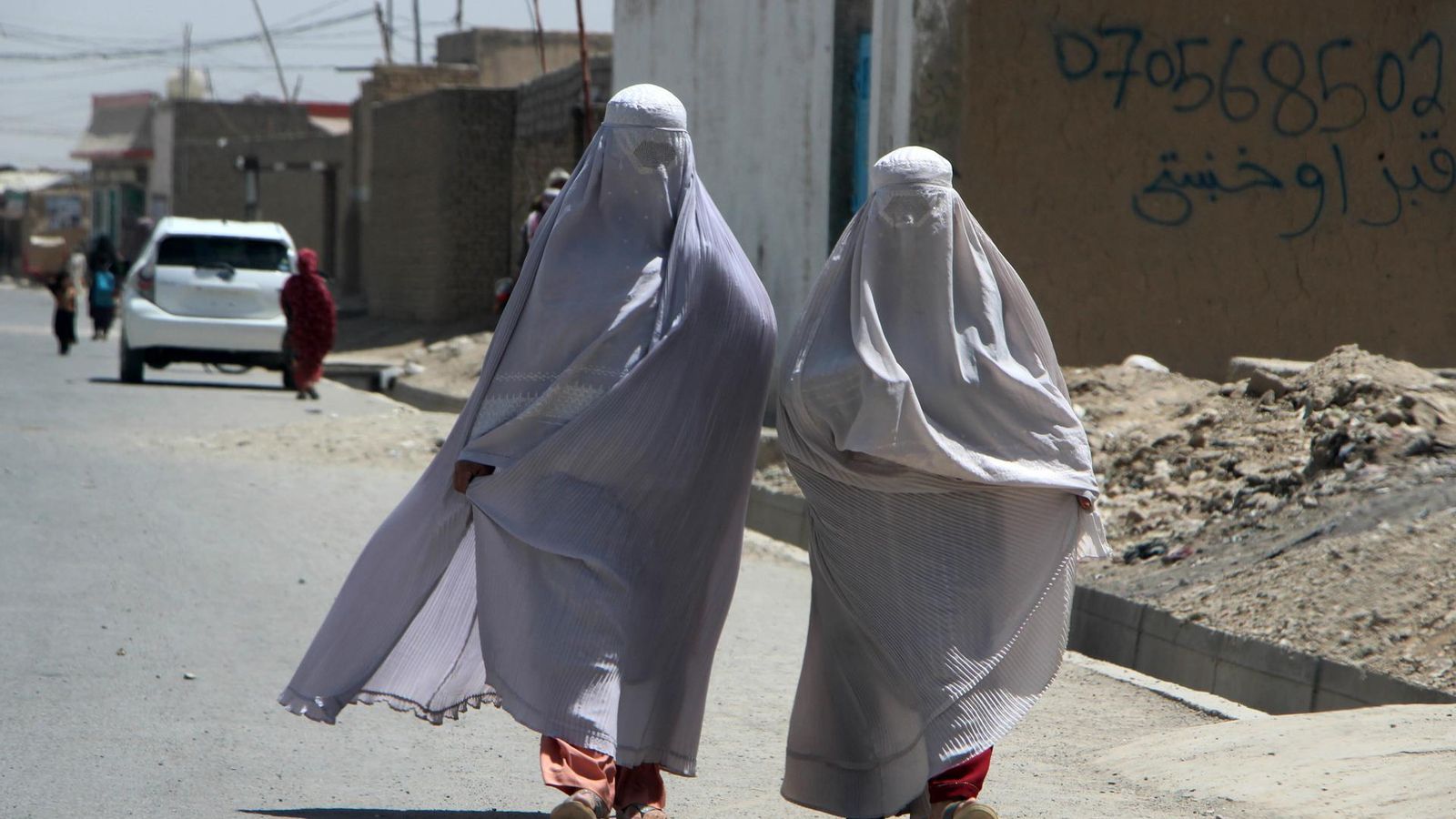 Dos dones afganeses vestides amb burca caminen per una carretera a la ciutat afganesa de Kandahar, el 22 d'agost de 2024 Dos dones afganeses vestides amb burca caminen per una carretera a la ciutat afganesa de Kandahar, el 22 d'agost de 2024