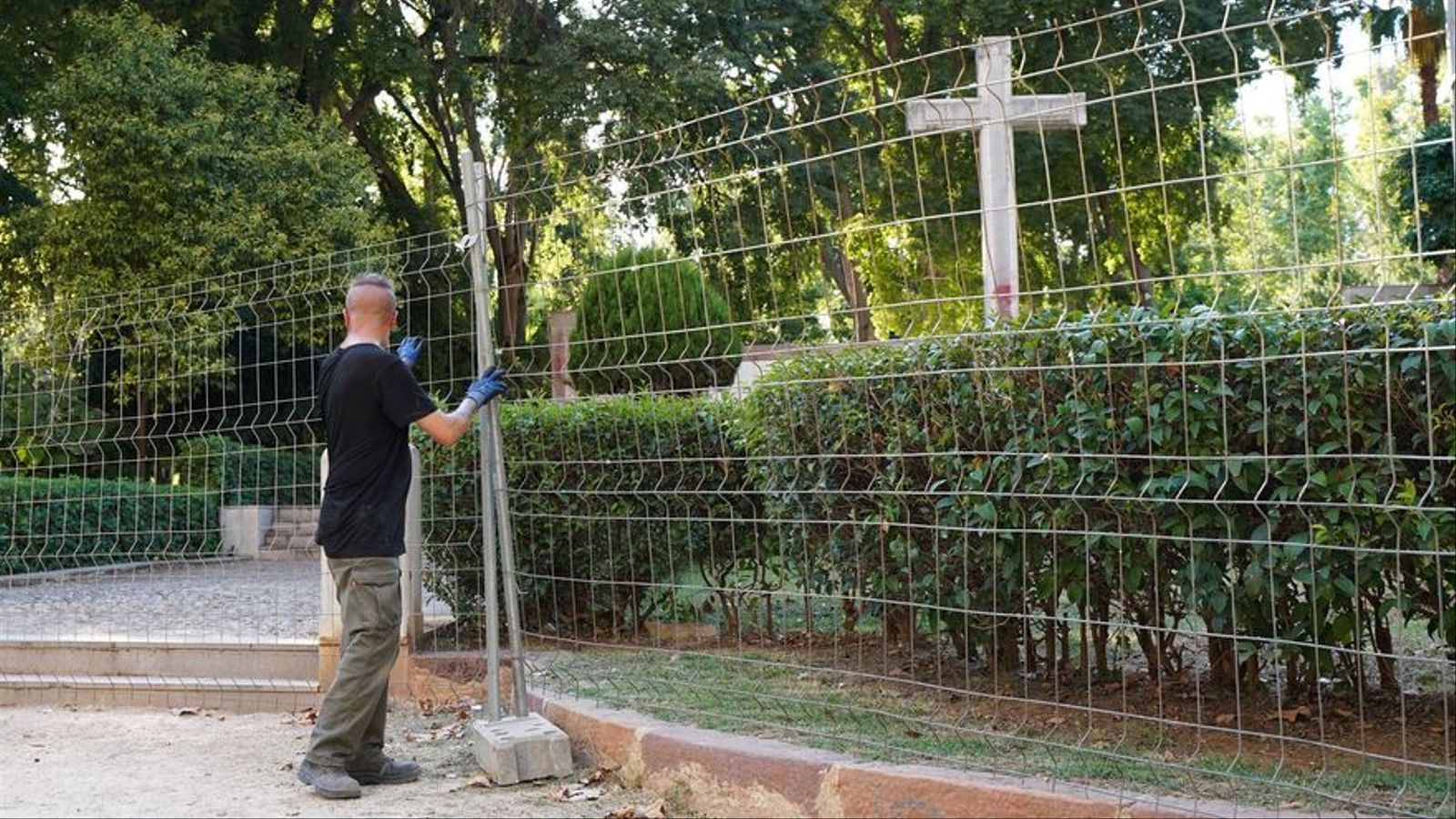 Un operari posa la tanca de protecció perquè es puguen dur a terme els treballs de desmuntatge de la creu de Ribalta