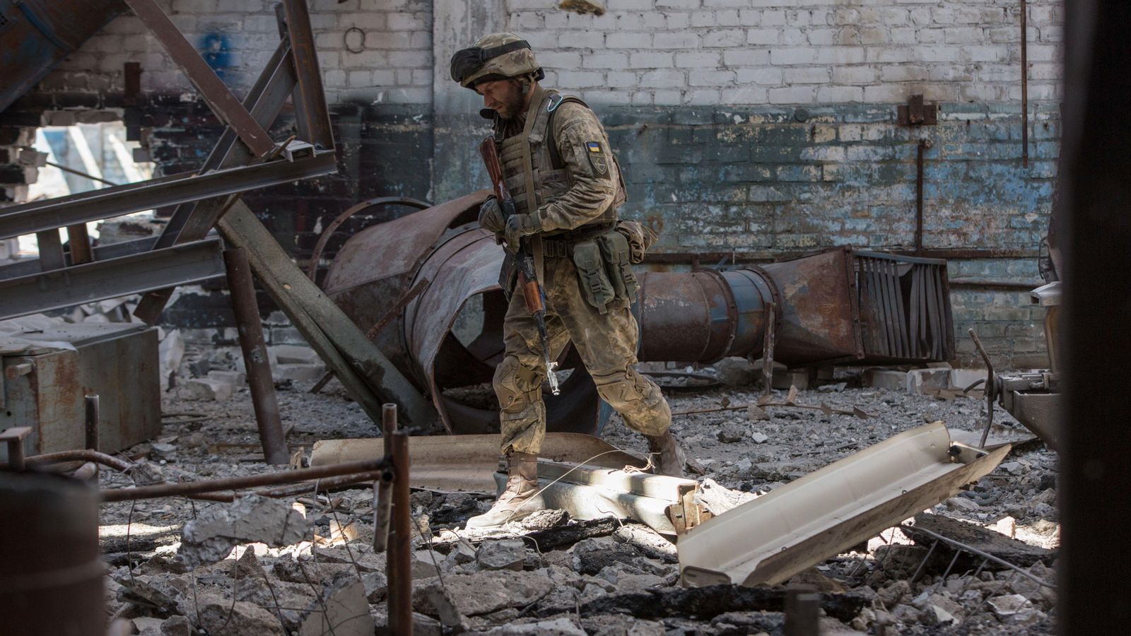Un soldat ucraïnés avança entre els enderrocs de la ciutat de Severodonetsk, que resiteix la pressió de les tropes russes