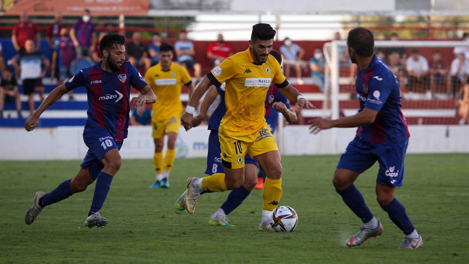 Un jugador de l'Hèrcules avança amb el balo davant la mirada dels jugadors de l'Alzira