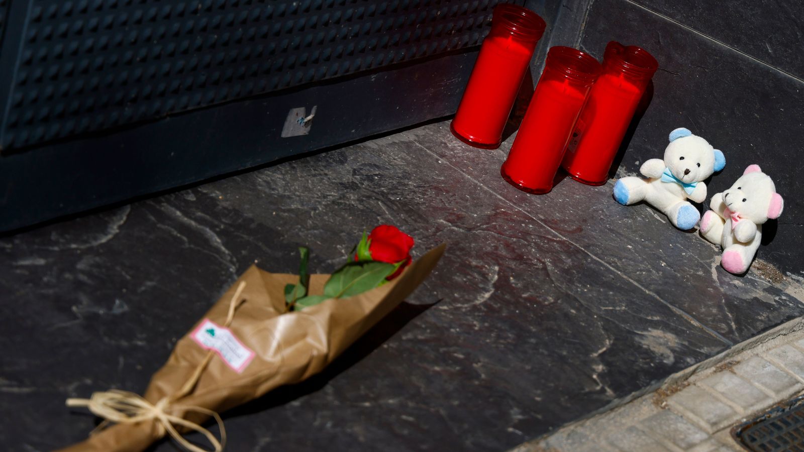 Una flor i diversos ciris, a la porta de la vivenda on residia la dona i els dos fills que han mort, recorden les tres víctimes