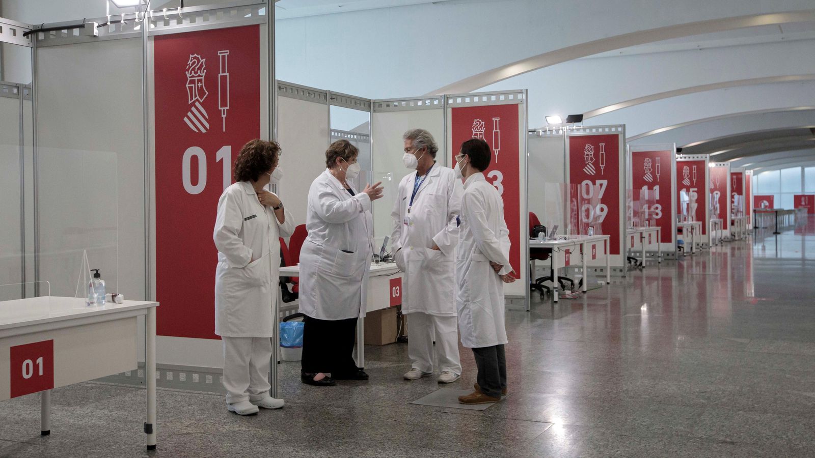 Un equip de sanitaris conversen en el punt de vacunació massiva habilitat a la Ciutat de les Arts de València, en una imatge d'aquest dissabte