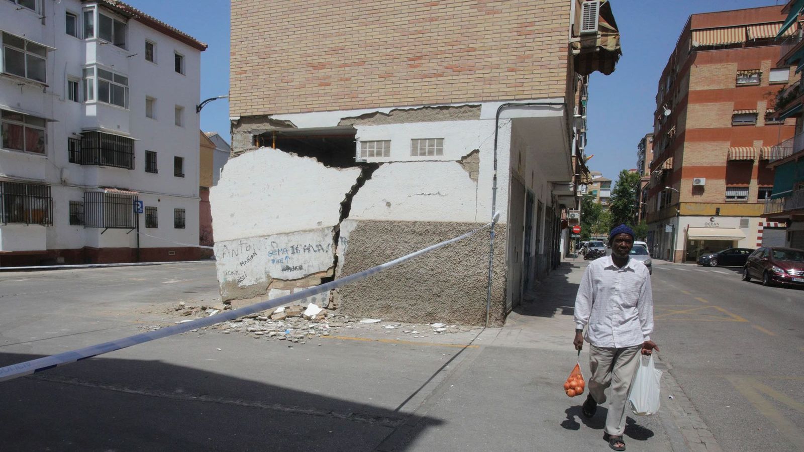 Un vianant passa pel costat d'un edifici danyat pels terratrémols que estan registrant-se a la província de Granada des de dissabte
