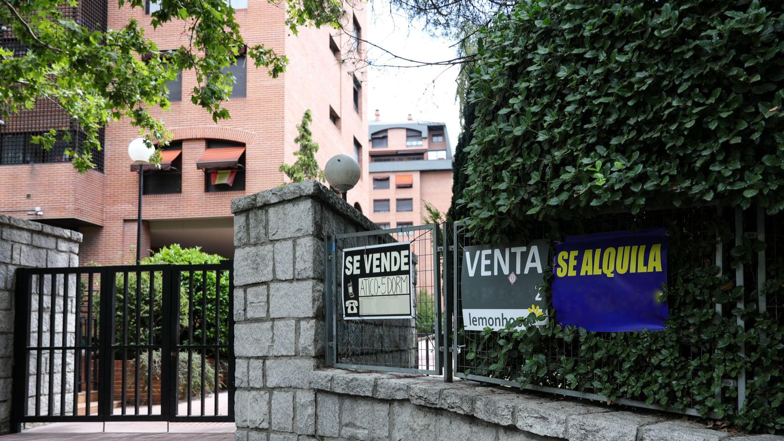 Diversos anuncis de vivendes en venda en la tanca d'una comunitat de veïns