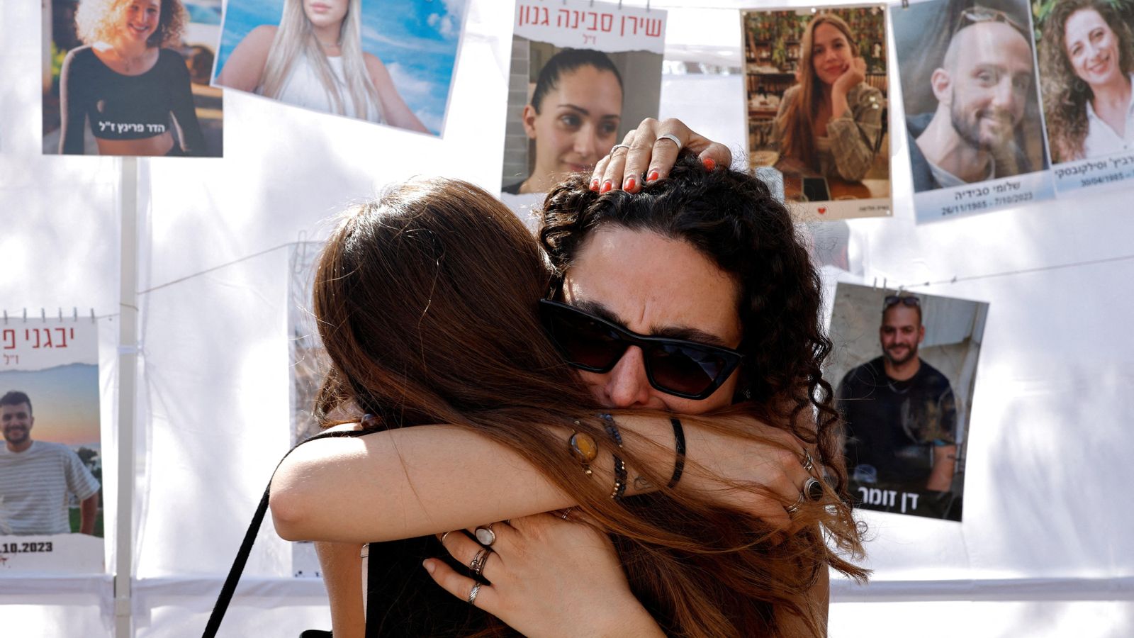 Dos dones s'abracen en el memorial de les víctimes de Hamàs que s'ha instal·lat en el recinte del festival de música Nova