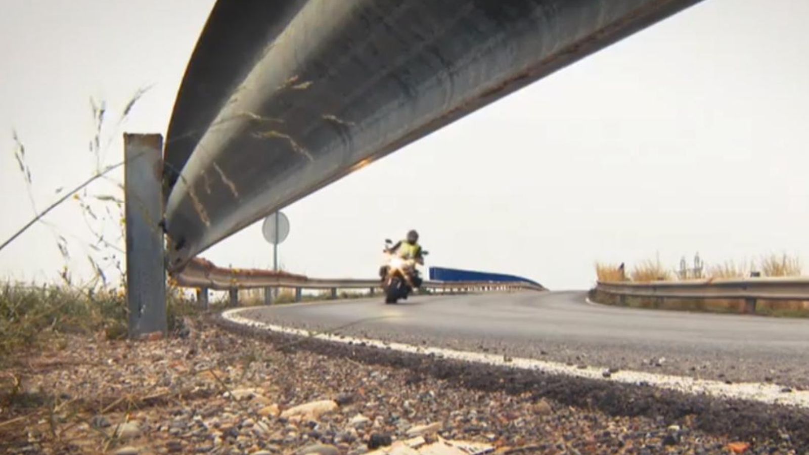 Un motorista circula per una carretera secundaria