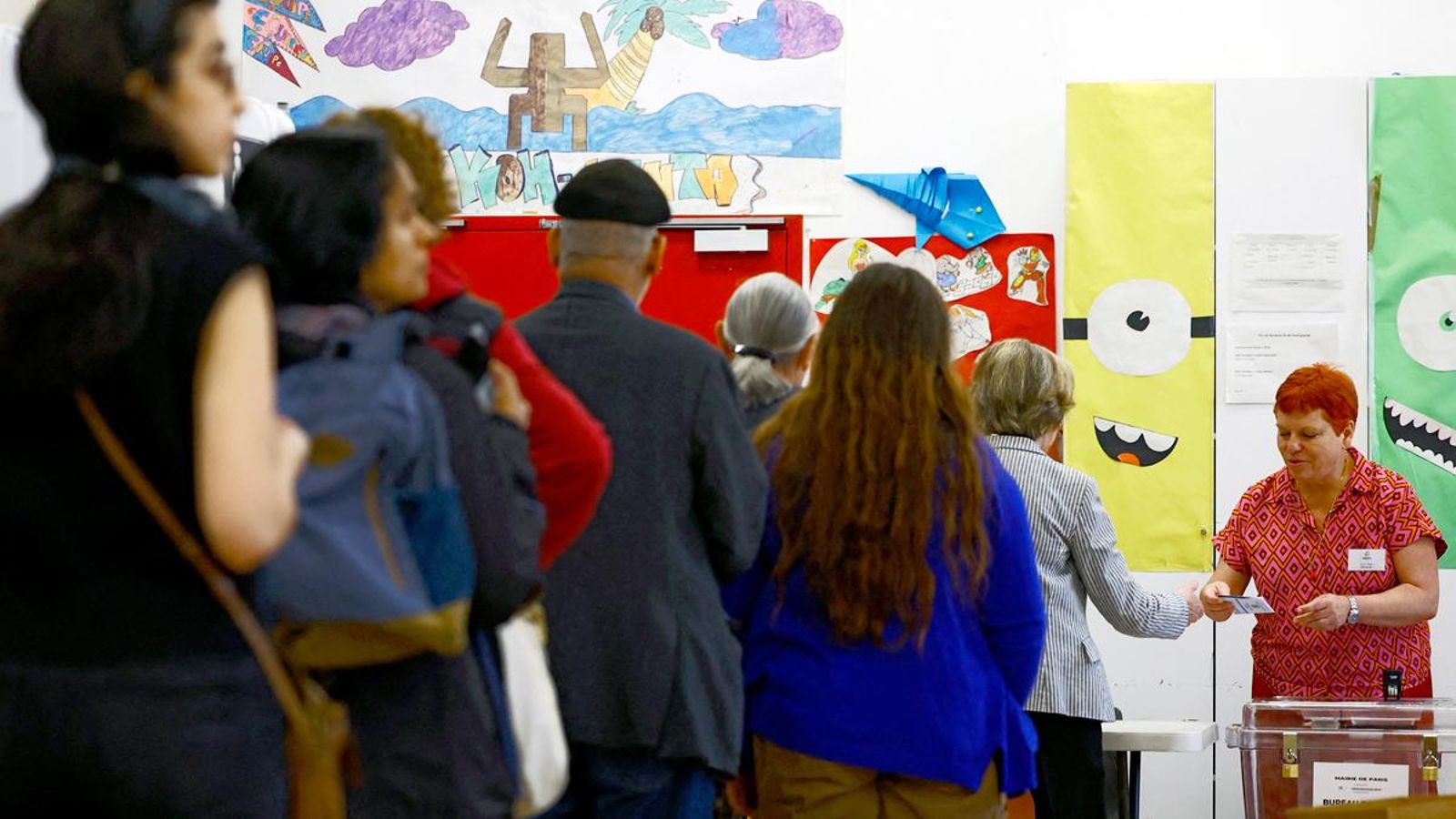 Gent fent cua en una escola de París