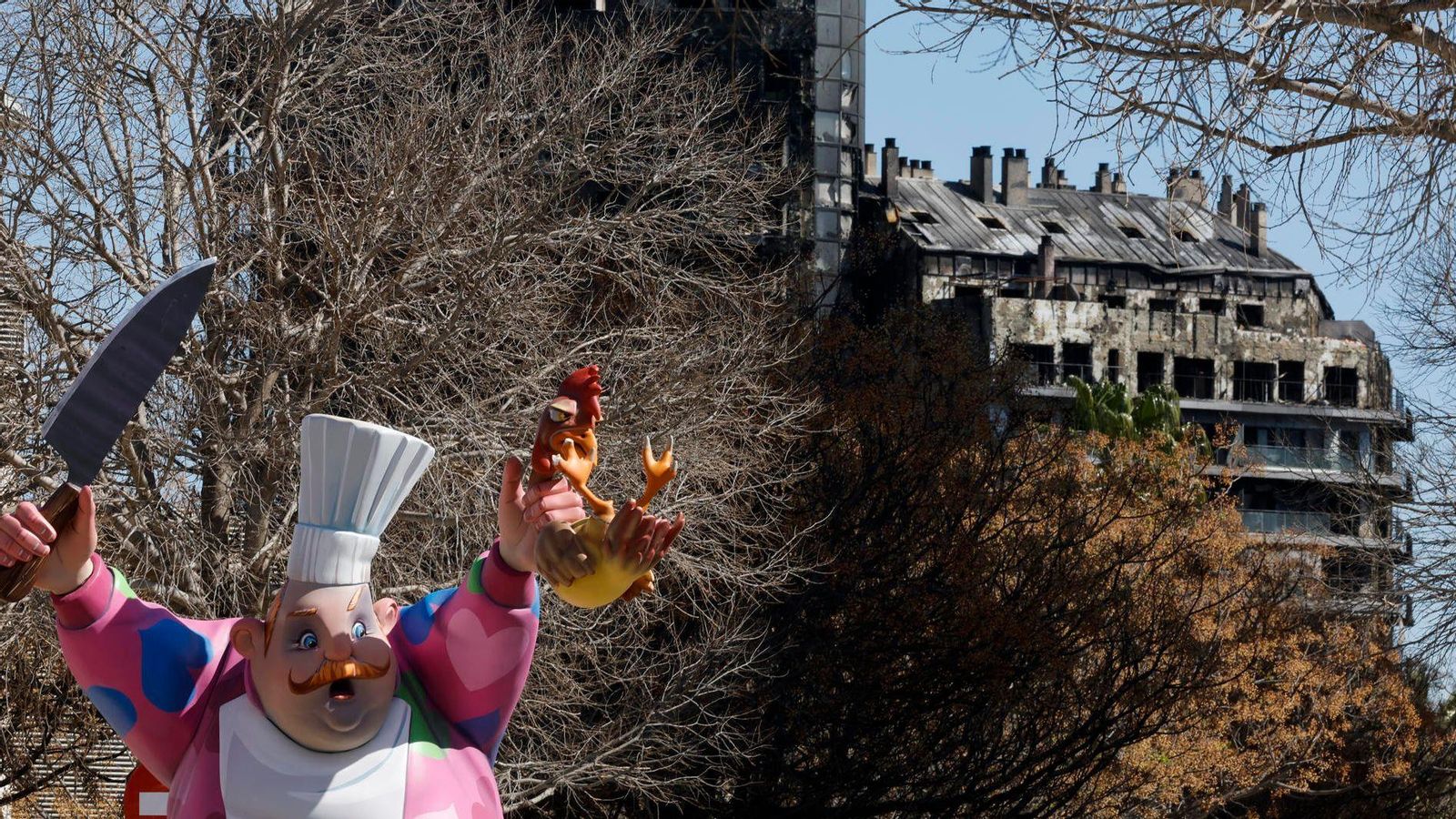 Vista del remat superior de la falla gran de La Nova de Campanar, amb l'edifici cremat de fons
