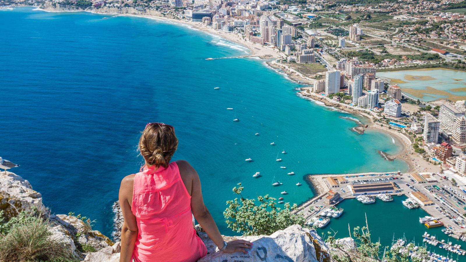 Una jove descansa al cim del penyal d'Ifach a Calp