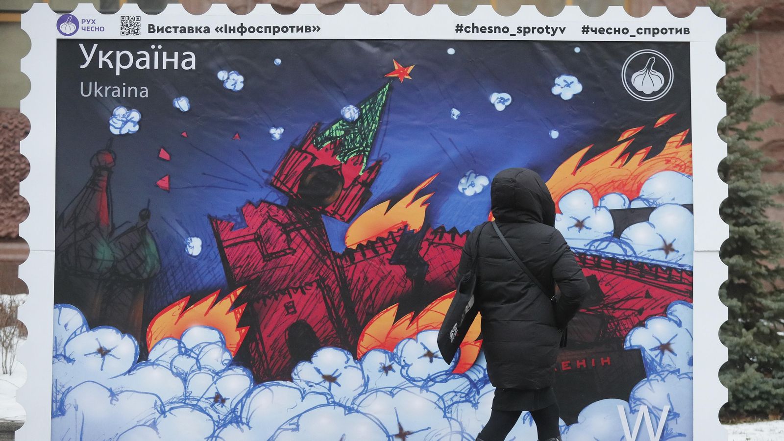 Una dona observa un segell a gran escala que mostra al Kremlin en flames, aquest dilluns a Kíiv, Ucraïna