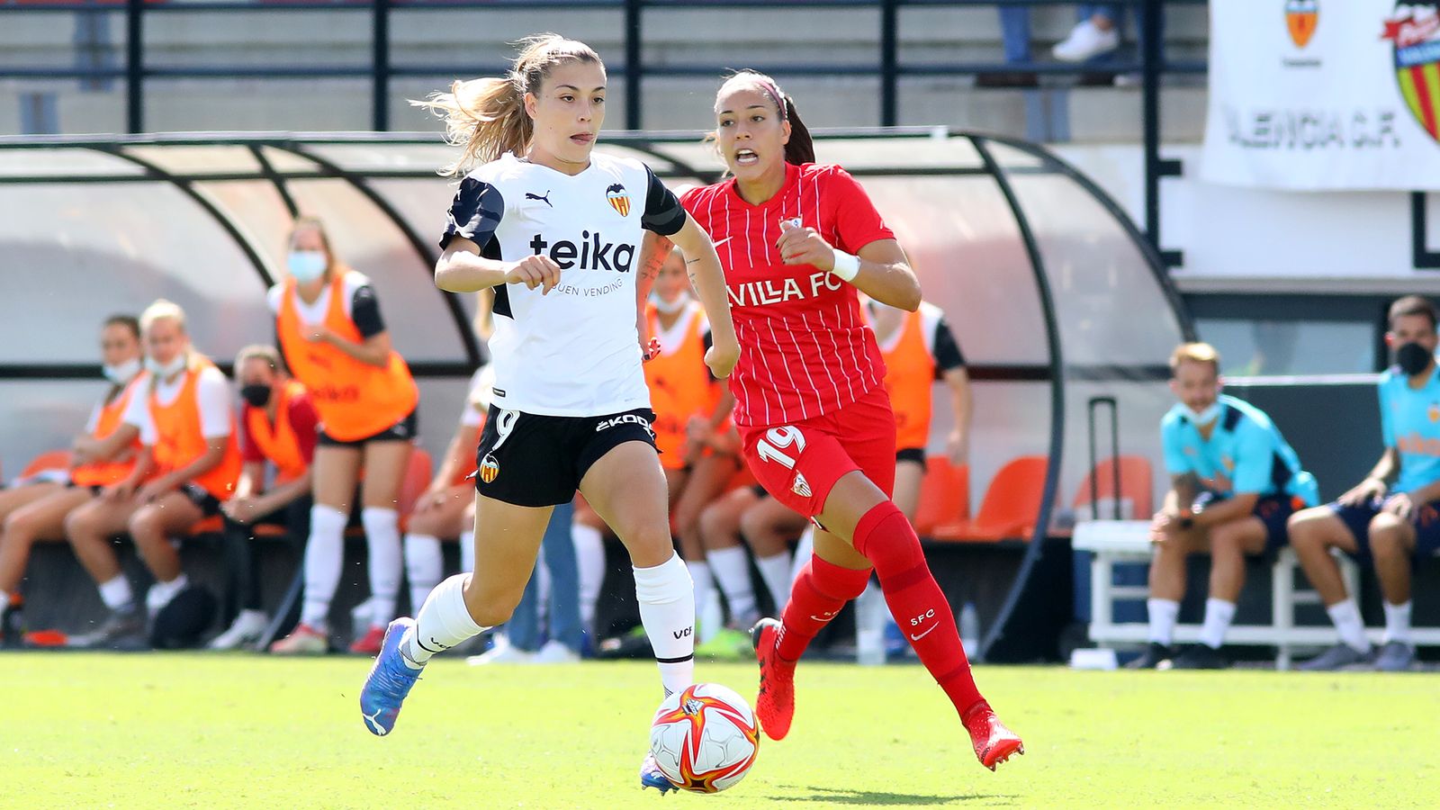 La valencianista Asun avança amb el baló perseguida per una jugadora rival