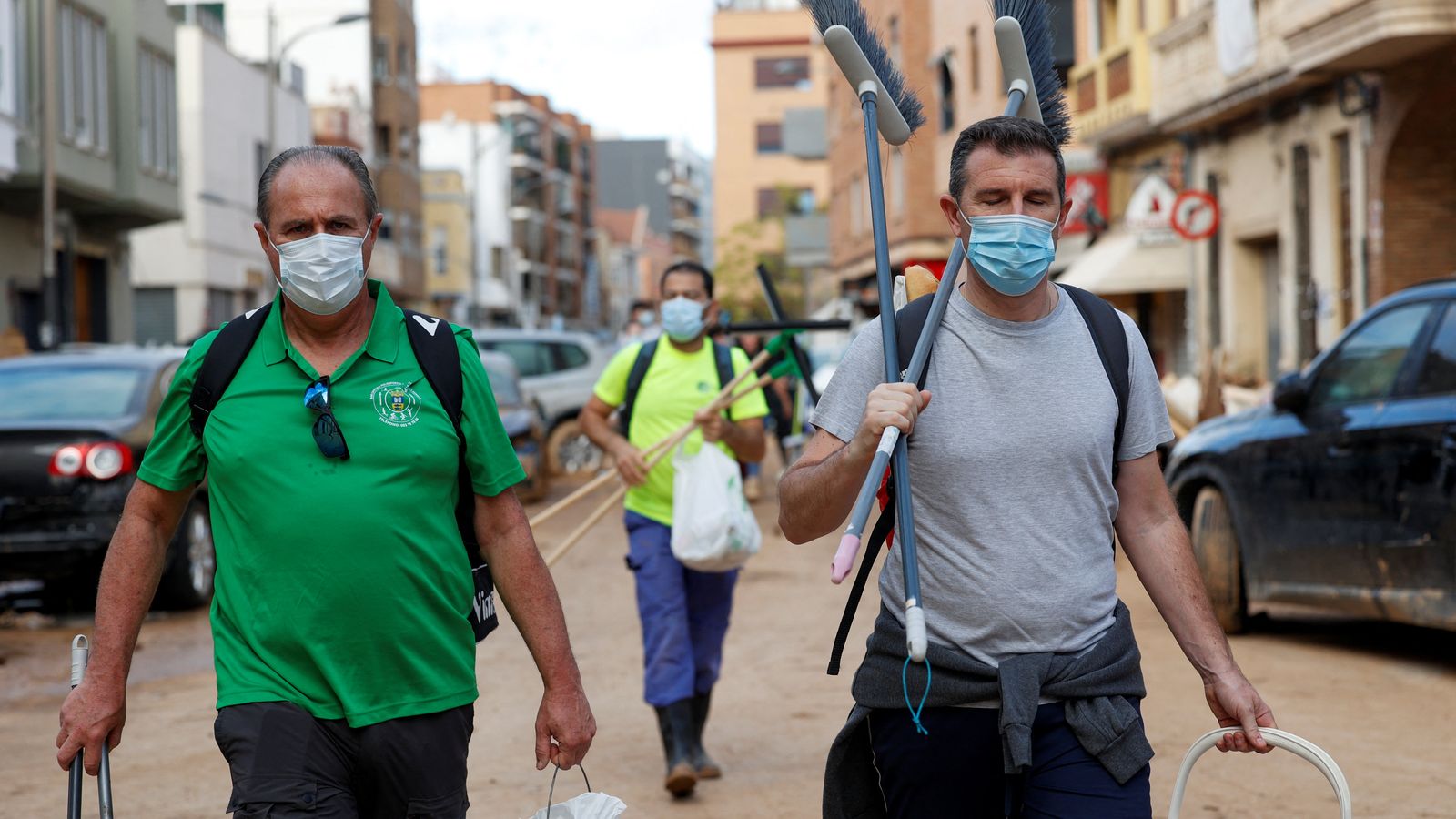 Tres persones amb mascareta netegen els efectes de la DANA a Sedaví