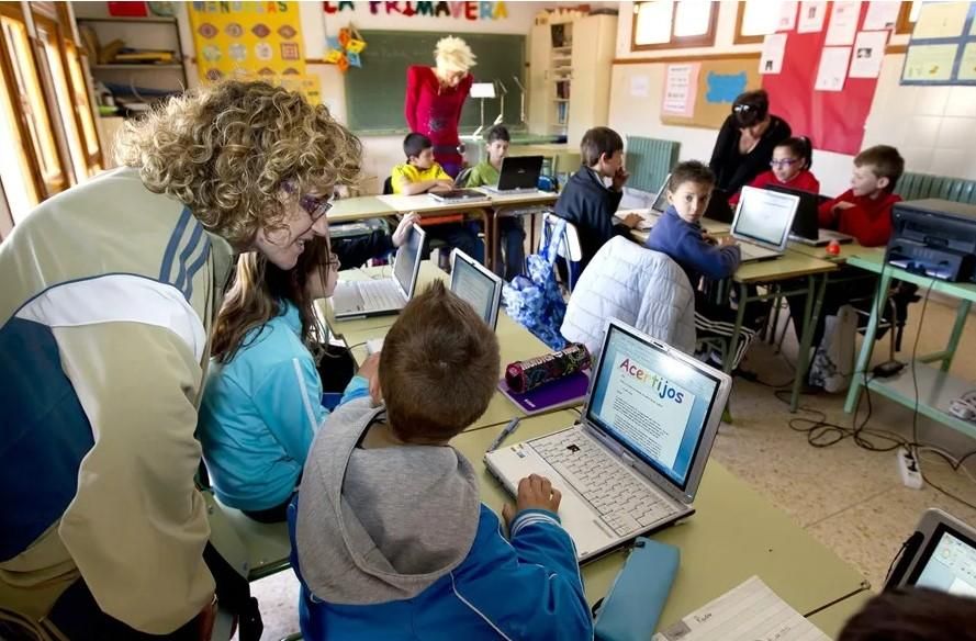 Escolars amb portàtils en una aula