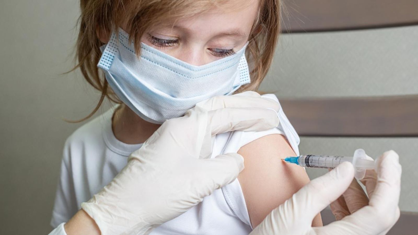 Una menor amb mascareta rep una vacuna