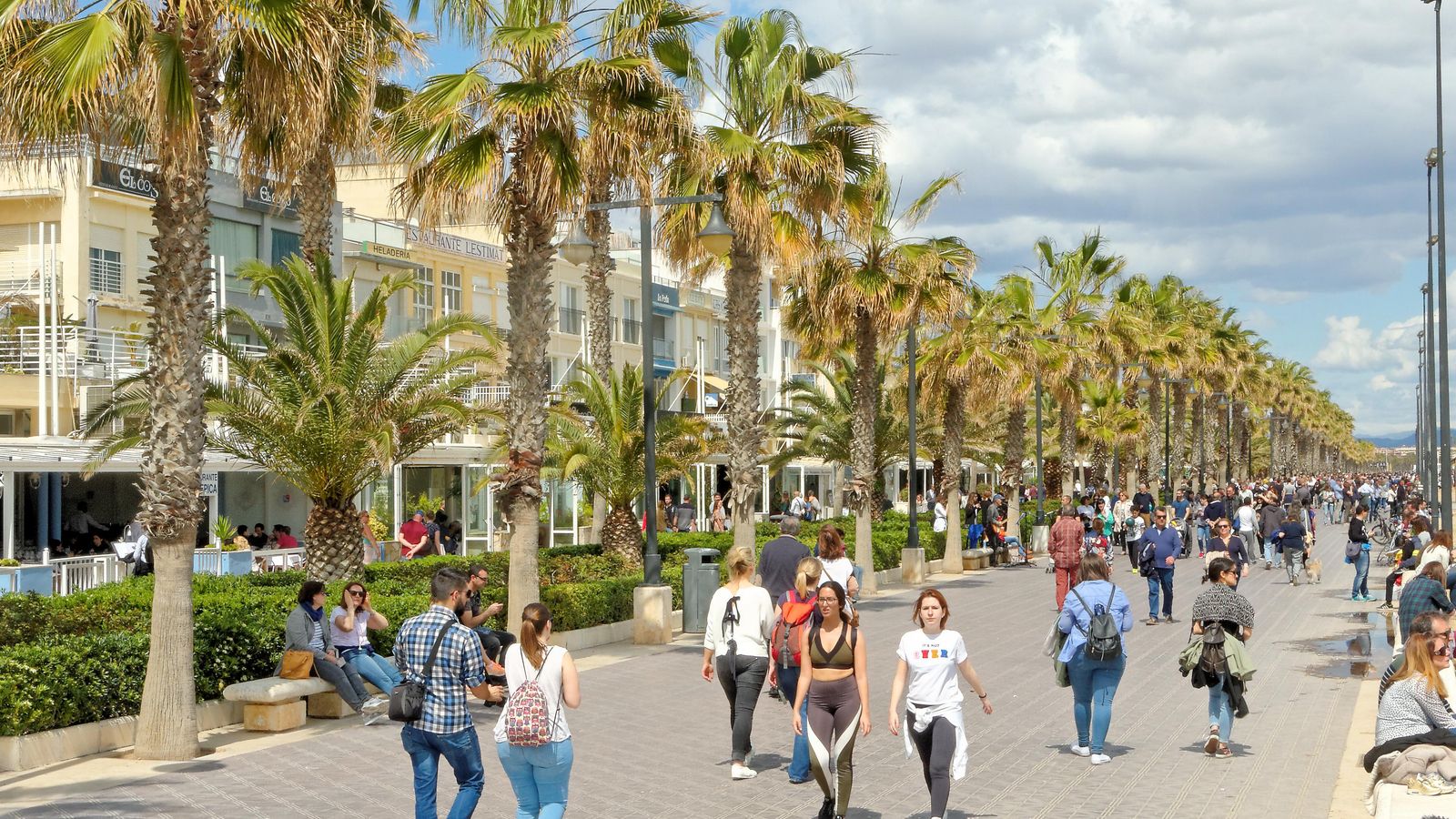Diverses persones passegen per la platja Malva-rosa de València