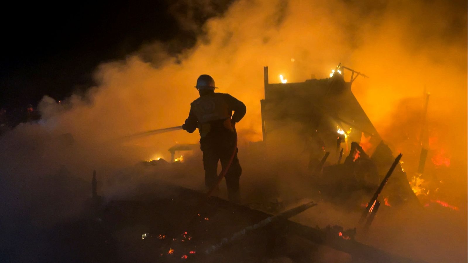 Palestins intenten extingir les flames d'un dels atacs a Khan Yunis, al sud de la Franja de Gaza