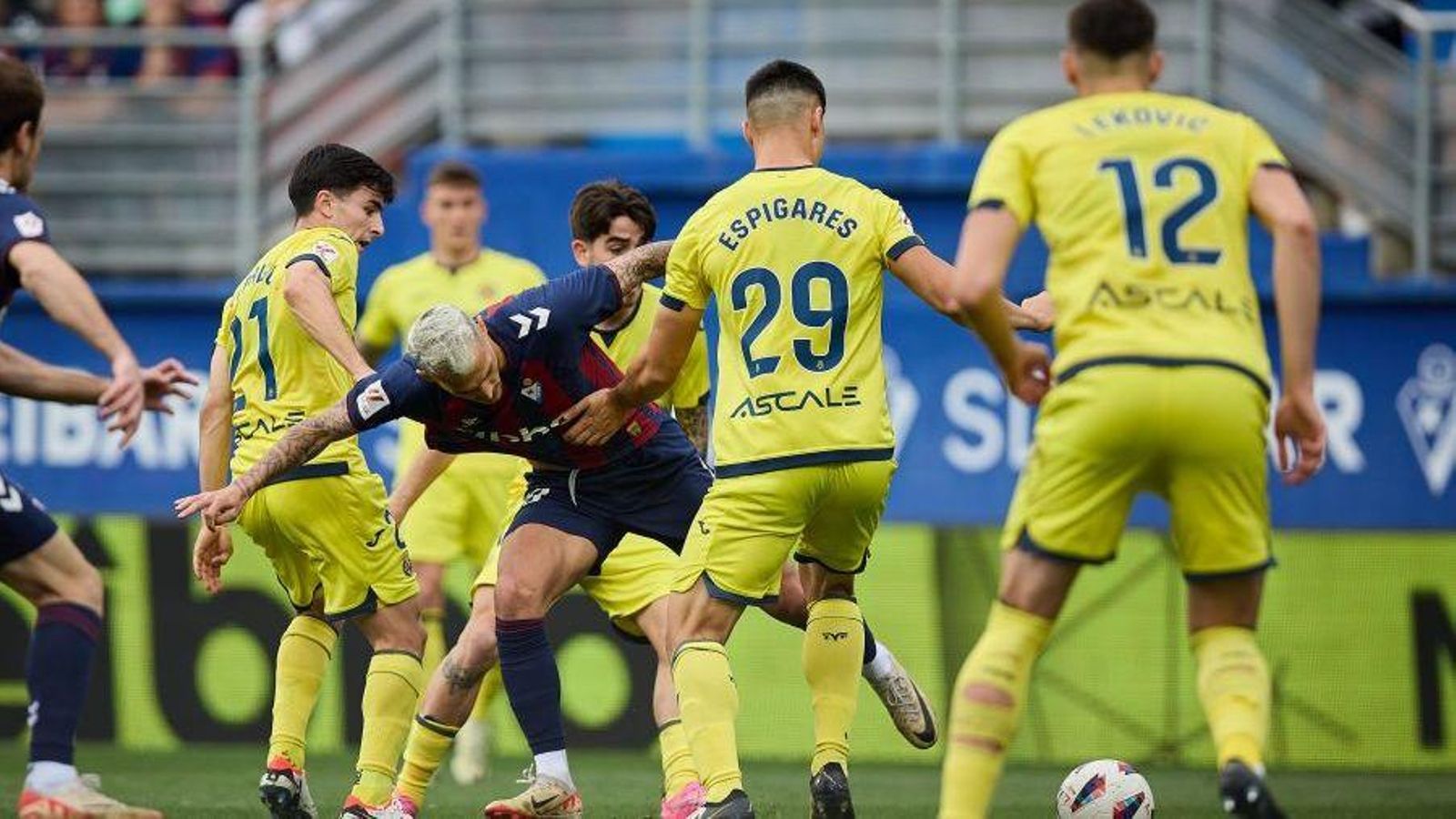 Els jugadors groguets tracten de recuperar la pilota