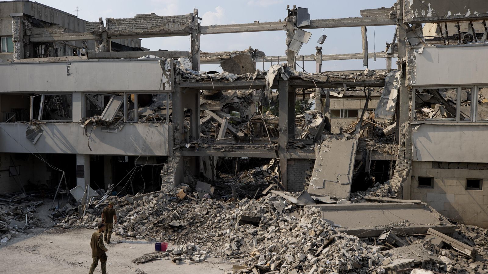 Dos soldats observa les ruïnes en la Universitat Pedagògica Hryhoriy Skovoroda completament destruïda en impactar un míssil rus el dimarts