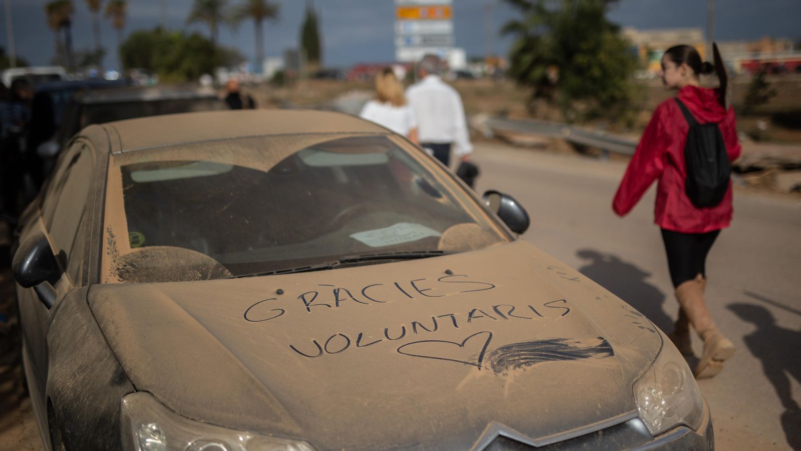 Un vehicle particular cobert de terra a un dels municipis afectats, amb un missatge de suport als voluntaris