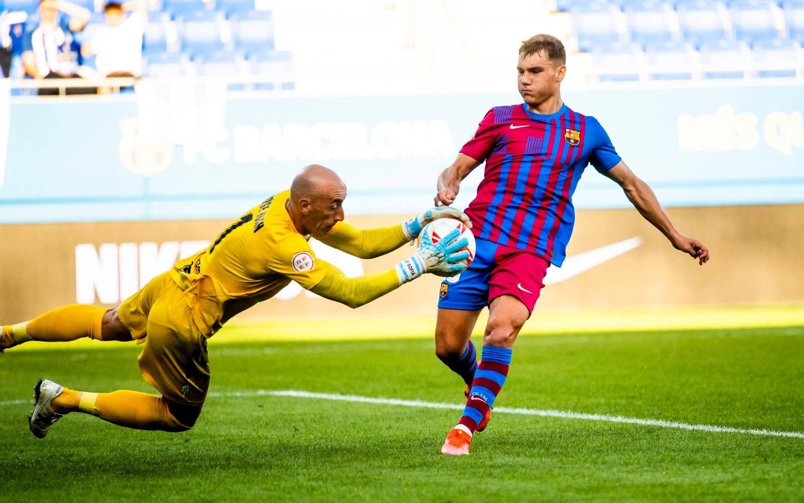 José Juan atrapa una pilota davant la pressió d'un jugador blaugrana