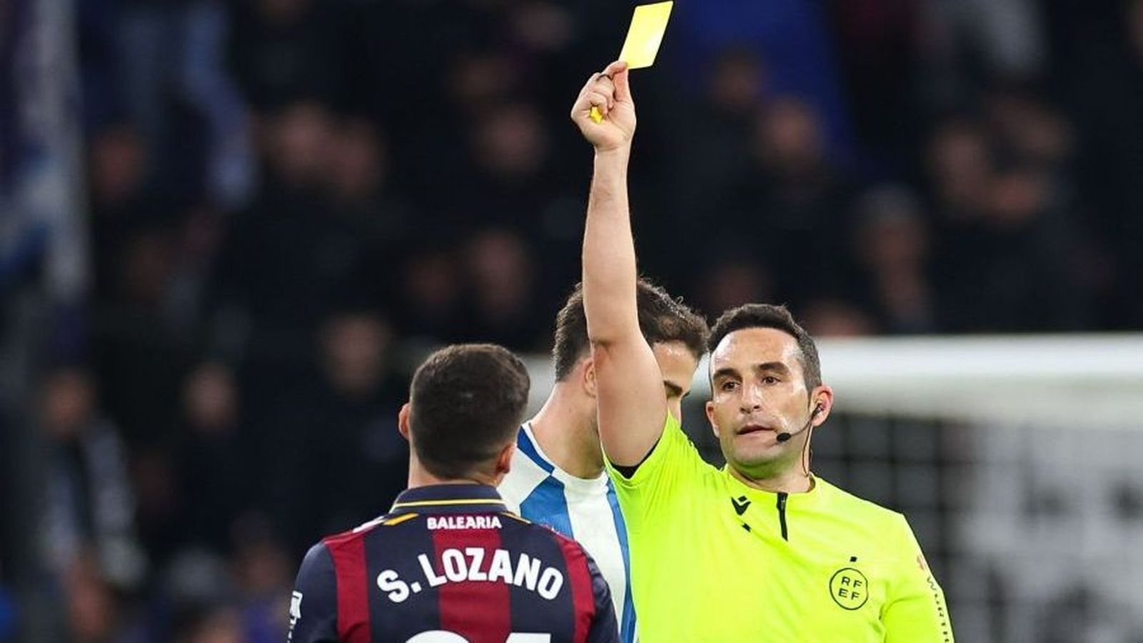 L'àrbitre amonesta Sergio lozano amb una targeta groga