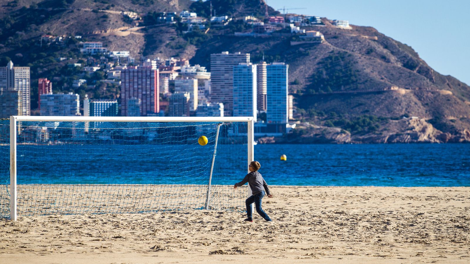 Un menor juga en una platja de la Costa Blanca buida de turistes