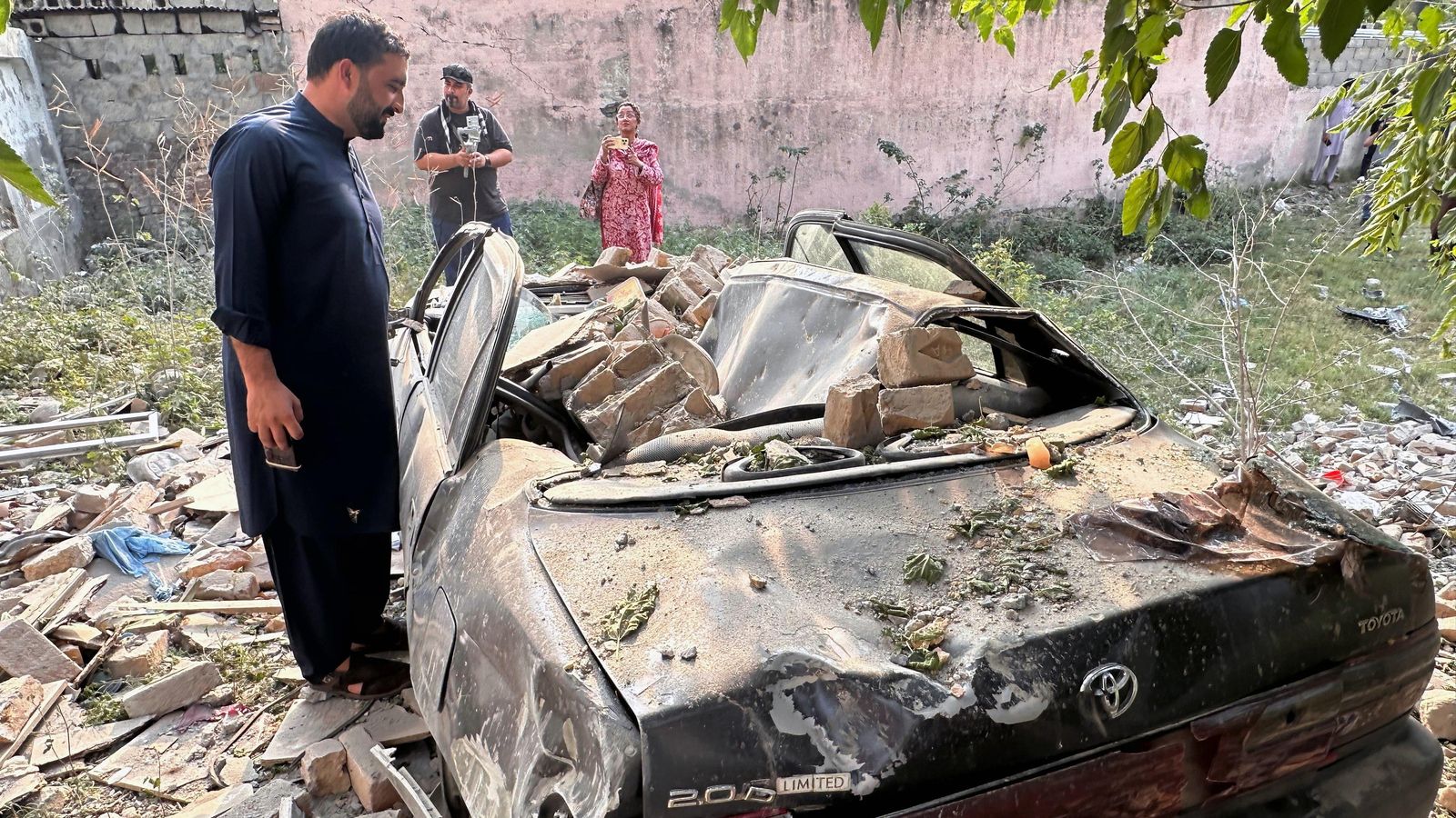 Un home observa un vehicle danyat després de l'atac amb míssils indis en Kotli, el Caixmir administrat pel Pakistan, este dimecres