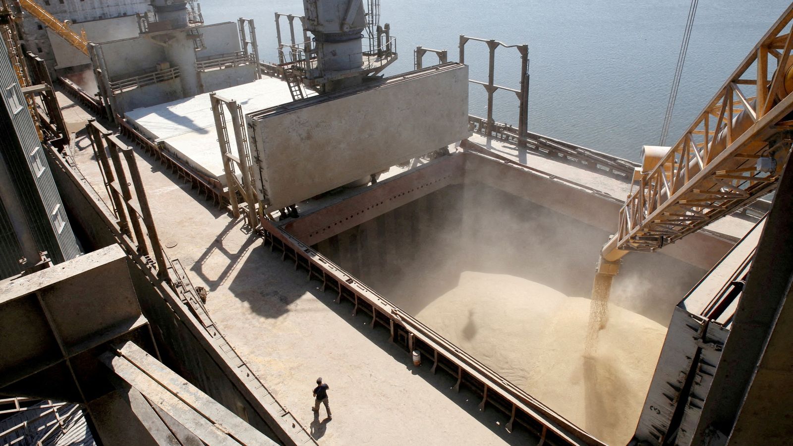 Un treballador  mira com s'aboca gra a un vaixell