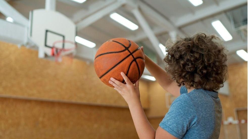 Un xiquet juga a bàsquet en una imatge d'arxiu