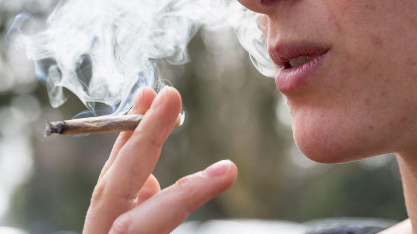 Una xica fuma un cigarret de marihuana