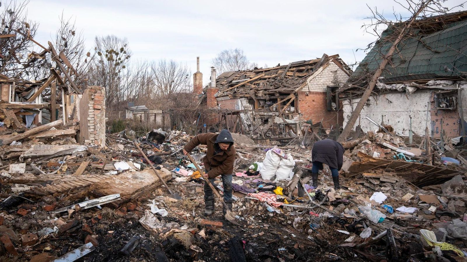 Dos homes netegen les restes després d’un atac aeri en la ciutat de Sloviansk, al Donetsk, una regió que controla Rússia i un dels esculls de la negociació