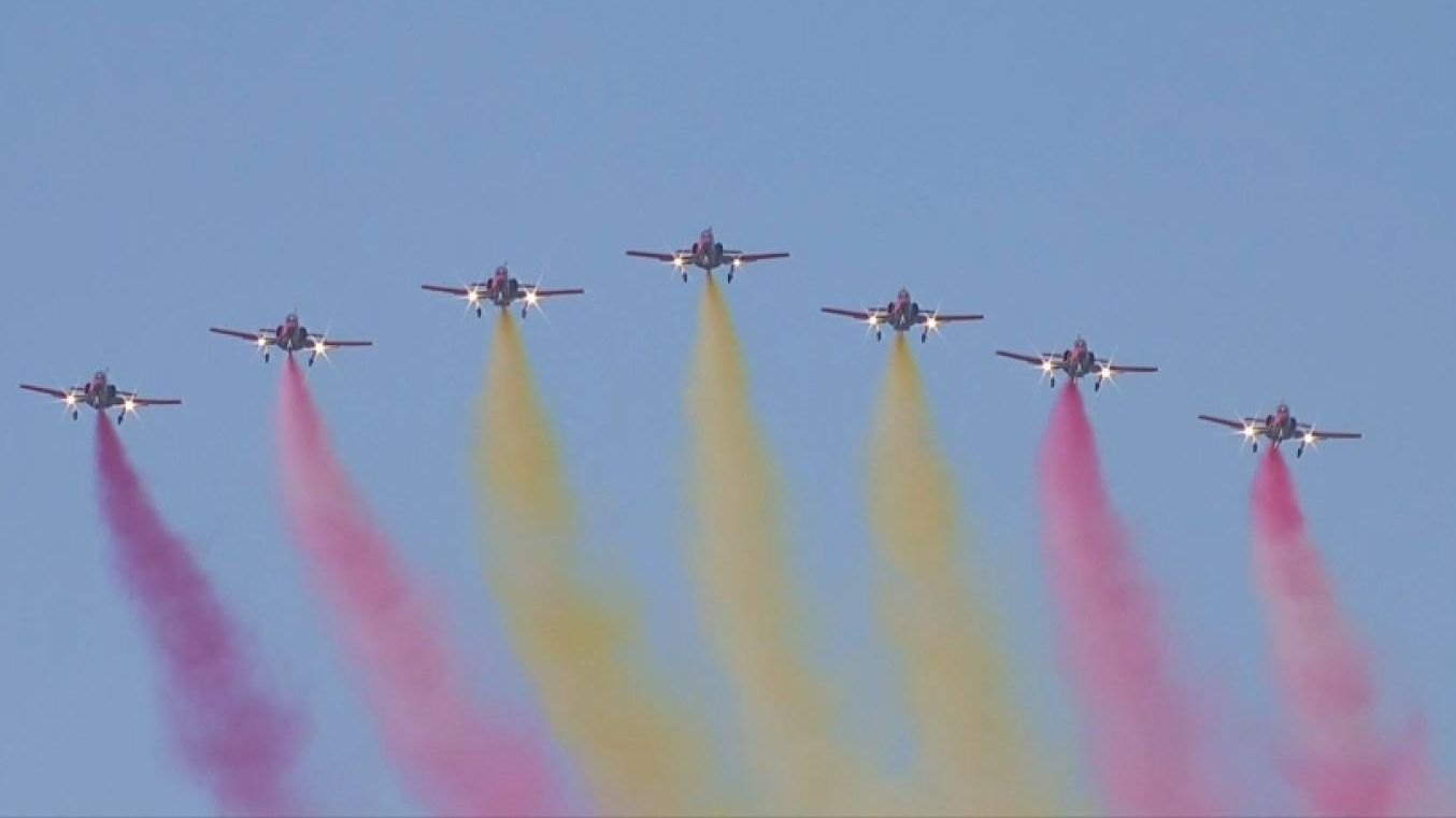 Imatge d'arxiu de la Patrulla Àguila pintant la bandera espanyola en el cel Moment en què el primer avió per l'esquerra creuava Madrid deixant un rastre morat