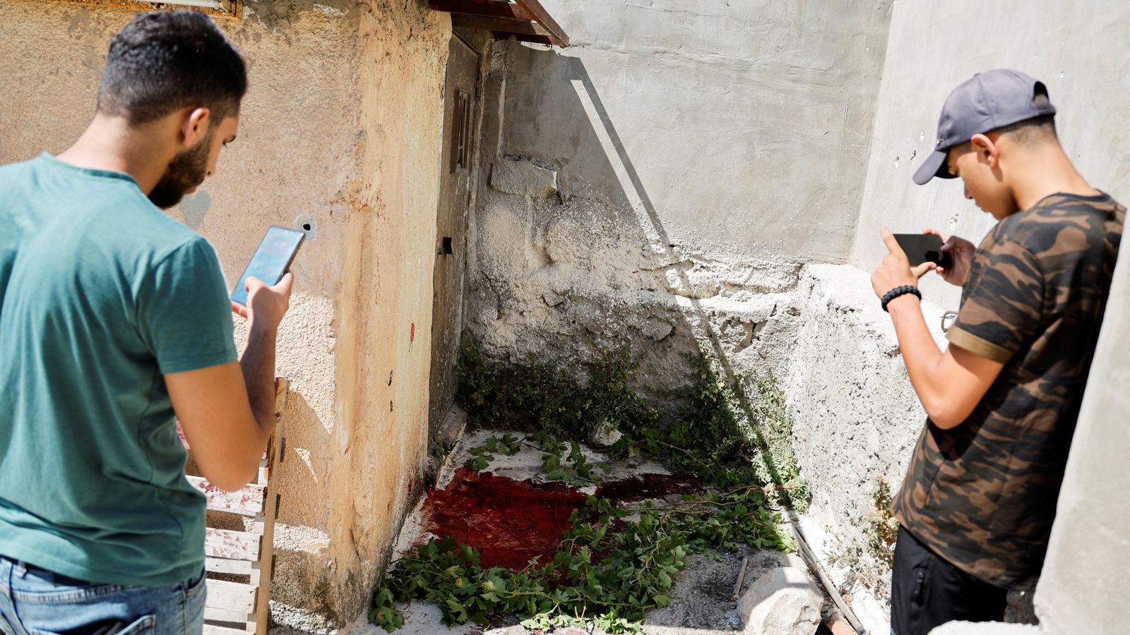 Dos palestins fotografien el lloc on ha perdut la vida un dels morts en la incursió militar
