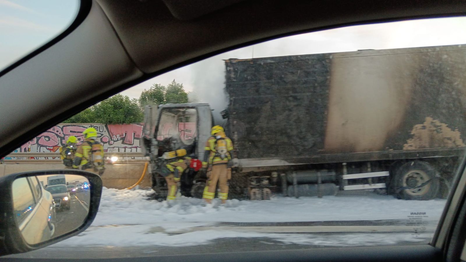 En imatge, l'extinció de l'incendi del camió accidentat a la V-30