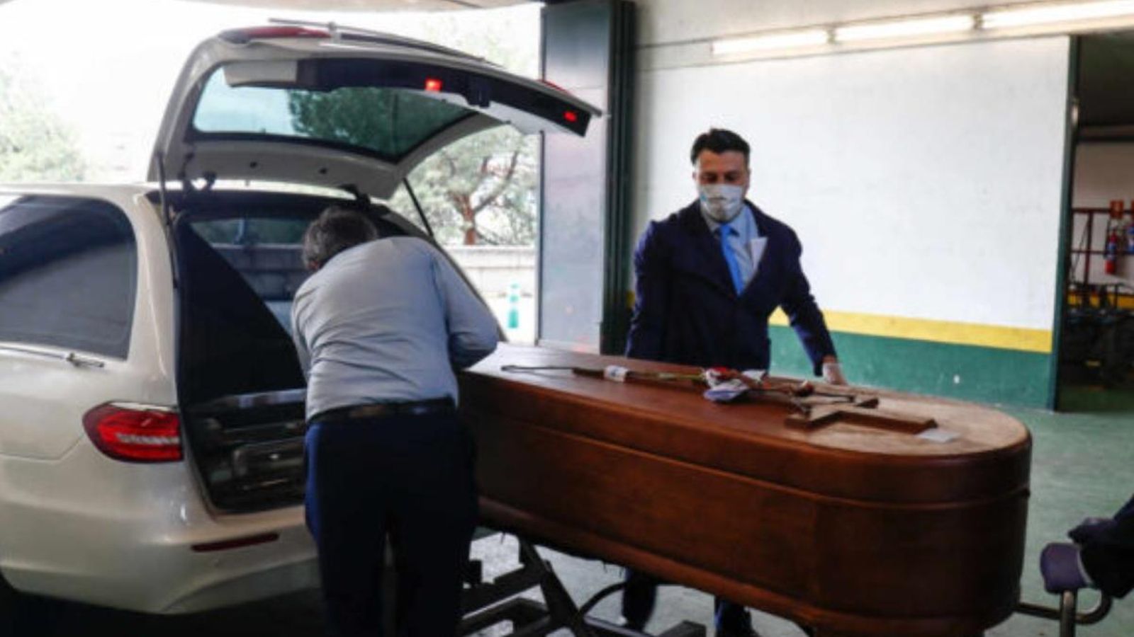 Diversos treballadors d'una funerària introdueixen un fèretre en un vehicle en una imatge d'arxiu