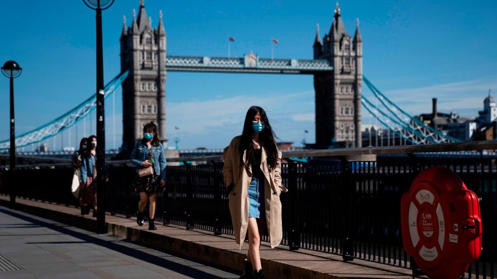 Un nombre reduït de persones passegen davant el 'Tower Bridge' a Londres
