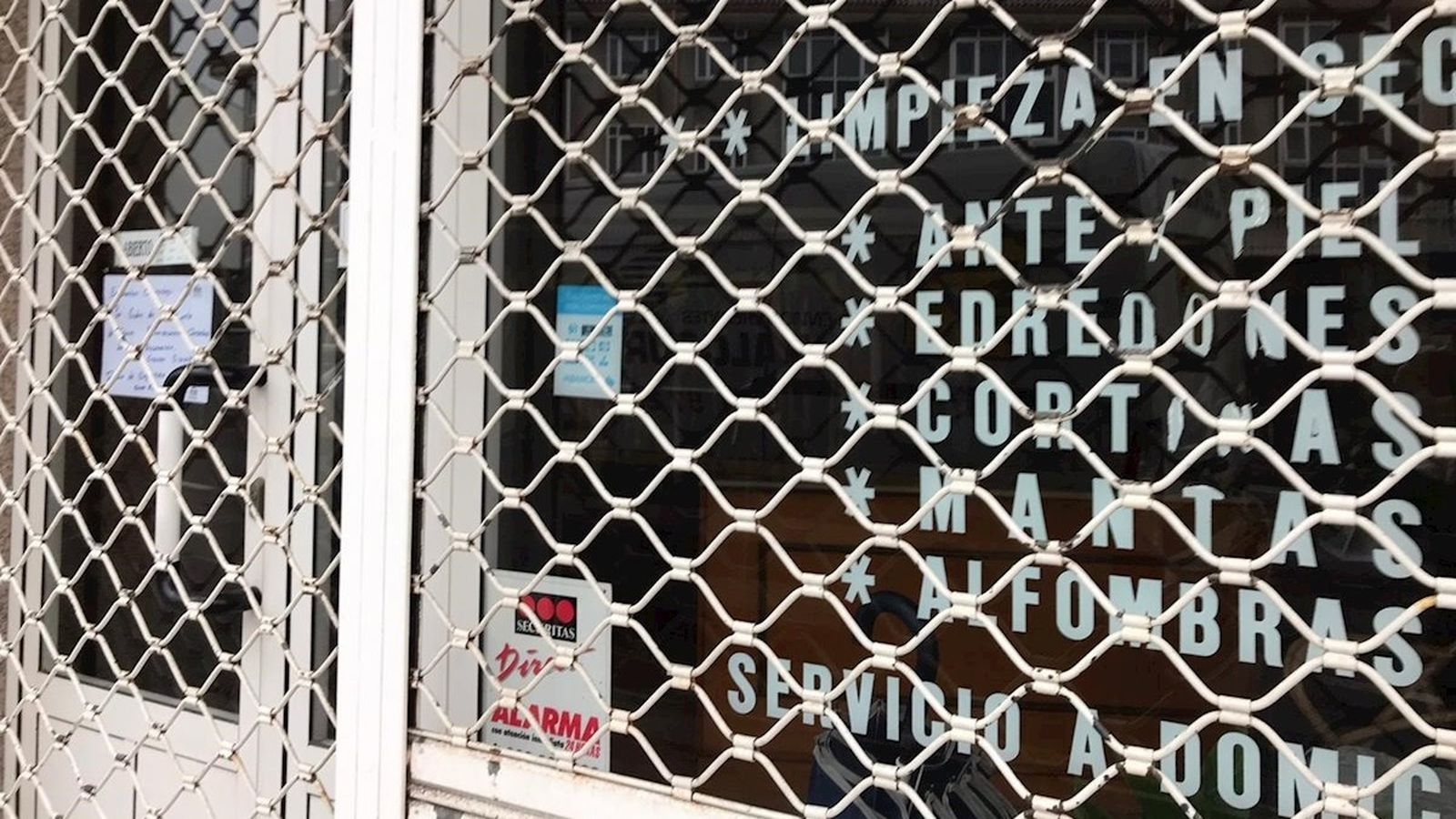 Façana d'una tintoreria que ha baixat la persiana per motius sanitaris a Toledo