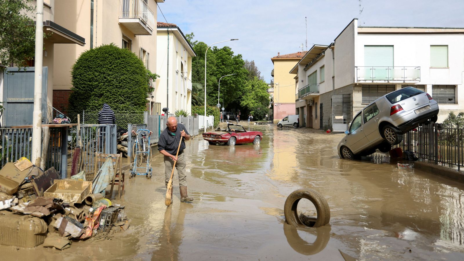 Un veí de Faenza, una de les localitats negades per la riuada, agrana el fang que han deixat les inundacions als carrers