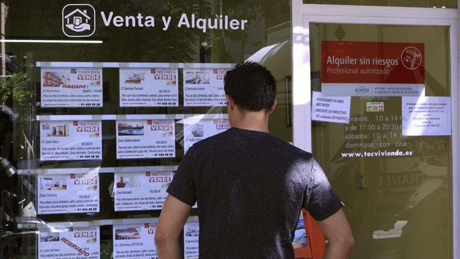 Un jove mira l'aparador d'una immobiliària en una imatge d'arxiu