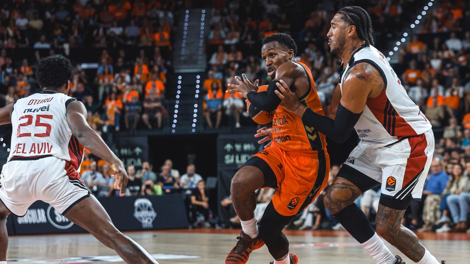 TJ Shorts es cola entre dos jugadors del Hapoel Tel-Aviv