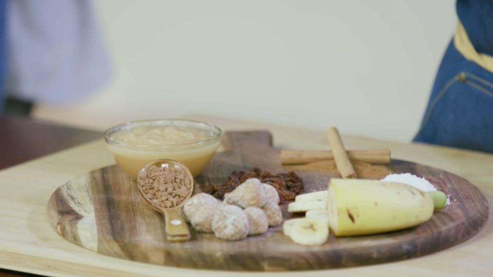 Dos rames de canella, un bol de compota de poma, un grapat de panses i figues seques, plàtan, coco ratllat i farina de garrofa