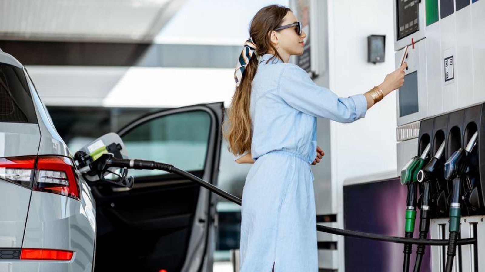 Una dona paga en la gasolinera en una imatge d'arxiu Una dona paga en la gasolinera en una imatge d'arxiu