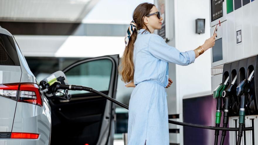 Una dona paga en la gasolinera en una imatge d'arxiu Una dona paga en la gasolinera en una imatge d'arxiu