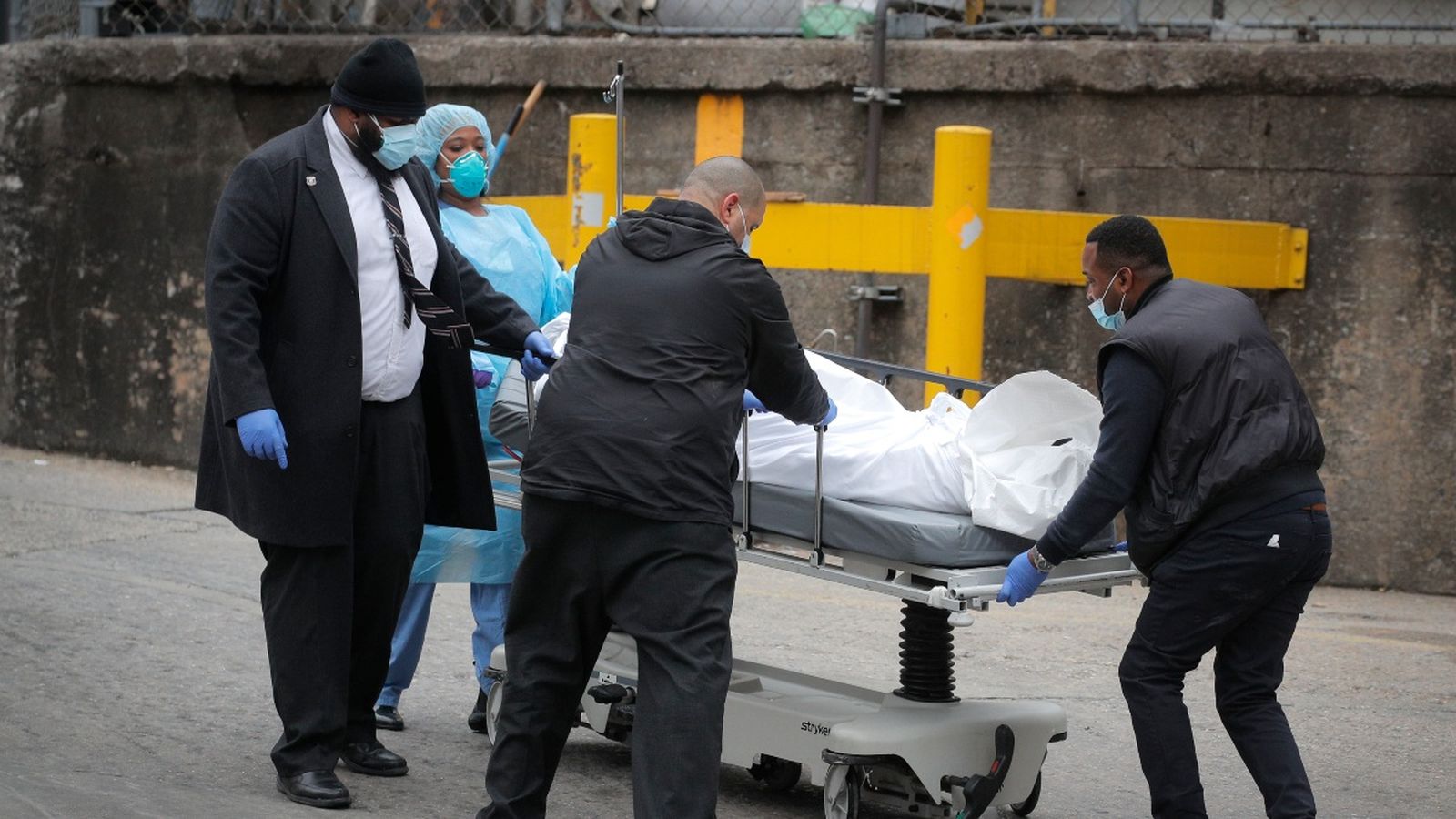 Un grup de sanitaris traslladen el cos d'un pacient mort per la Coivid-19 a un hospital de Nova York