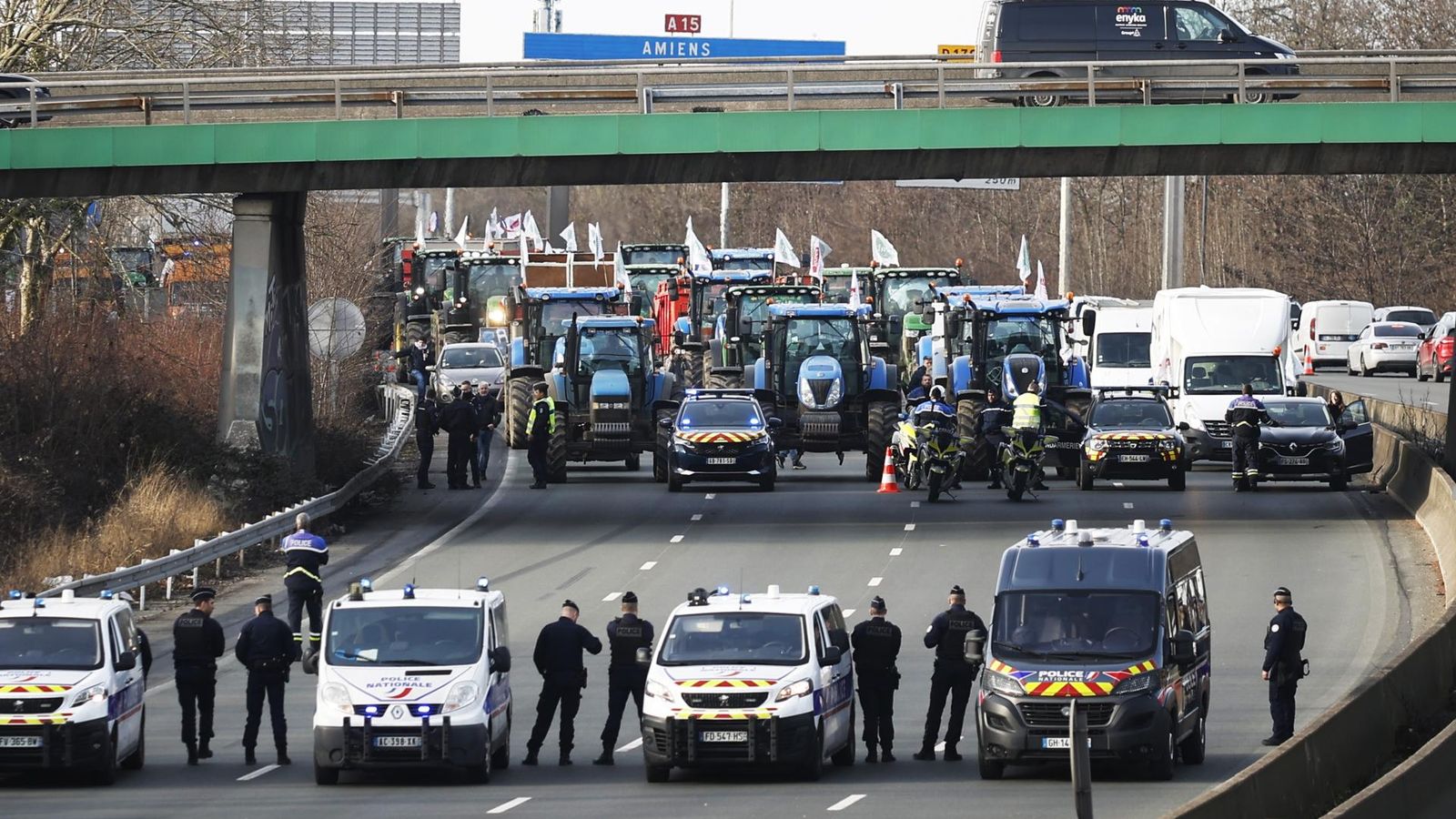 Un cordó policial vigila com decenes de tractors tallen la'utopista A15 prop d'Argenteuil, al nord de París