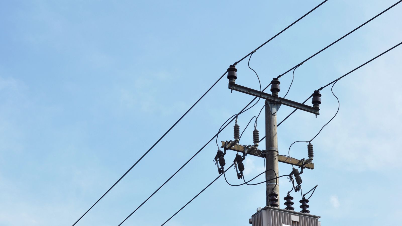 Imatge d'arxiu d'un transformador de distribució d'energia i línies aèries