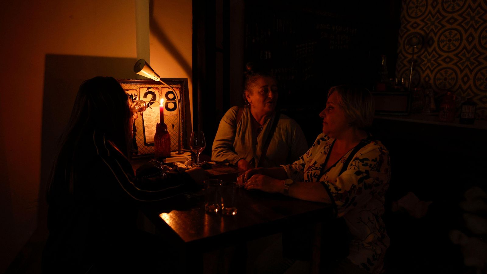 Clients d'un restaurant de València mengen amb la llum dels ciris